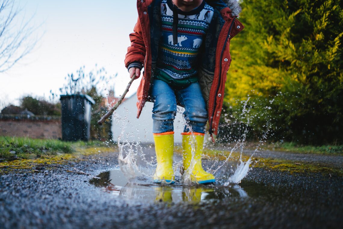 Photo of child splashing in a puddle