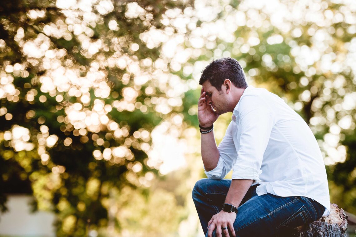 photo of man praying with concern outdoors