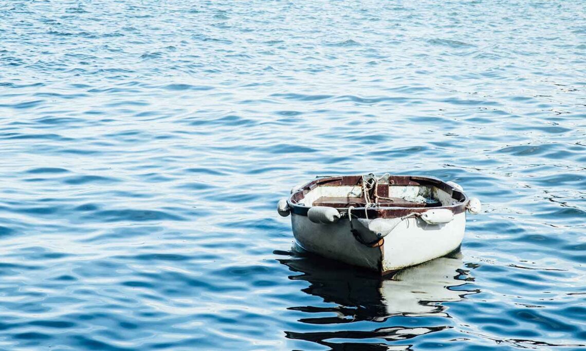 Photo of a rowboat adrift on the sea