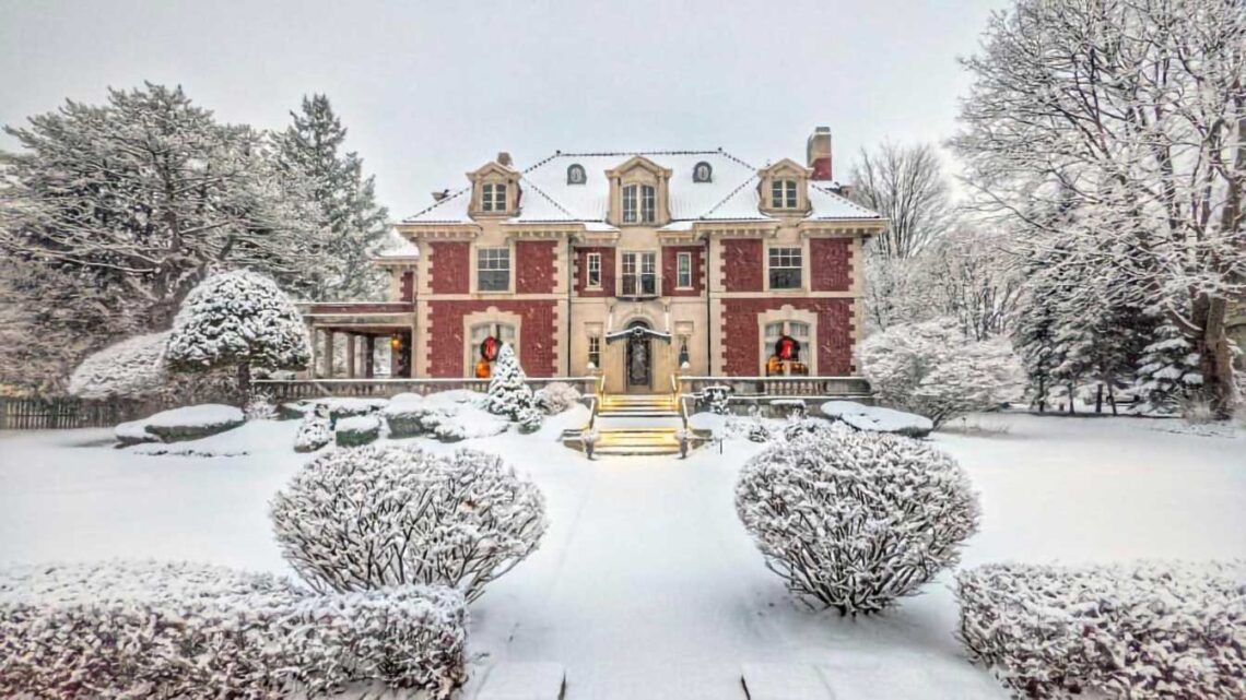 Photo of a brick mansion decorated for Christmas after a recent snowfall