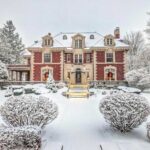 Photo of a brick mansion decorated for Christmas after a recent snowfall