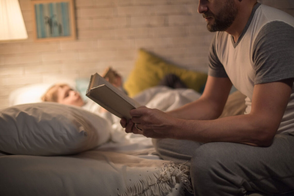 photo of a father reading a good night story to his son