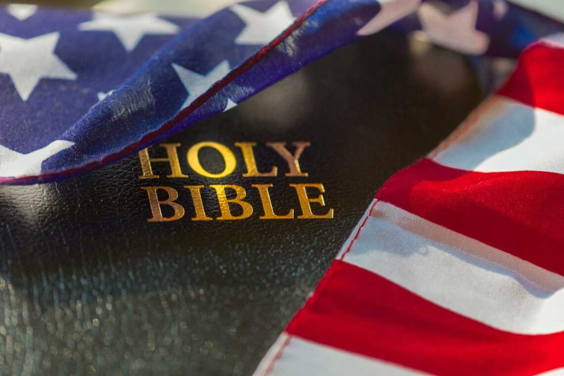 photo of an American flag draped over a Holy Bible