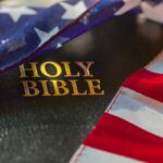 photo of an American flag draped over a Holy Bible